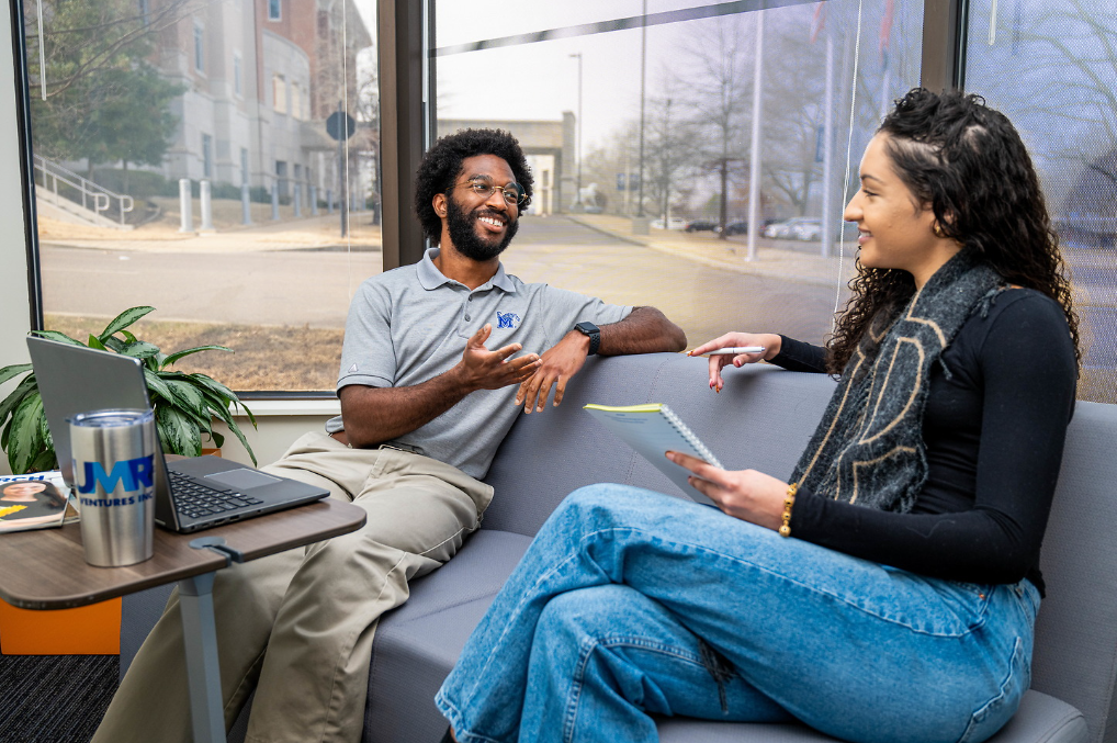 Two students talking on a couch